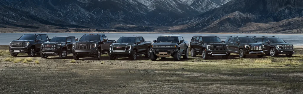 GMC truck and SUV lineup parked in scenic mountain landscape